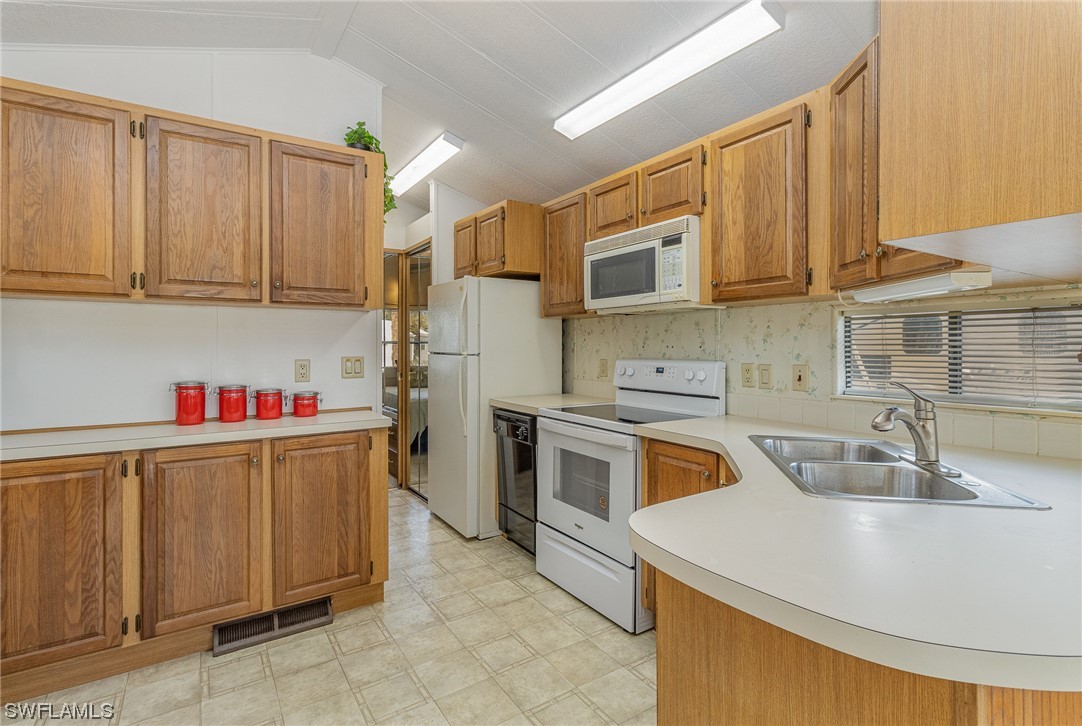 10844 Ani Circle Estero, FL 33928 - Photo 5 of 24 a kitchen with stainless steel appliances granite countertop a sink dishwasher stove and refrigerator with wooden cabinets