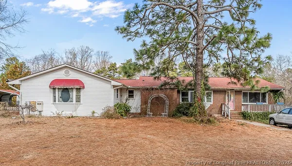 a view of a house with a yard and large tree