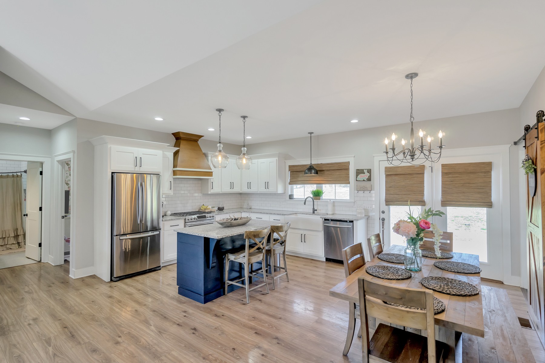 1687 Porter Road Burns, TN 37029 - Photo 7 of 32 a kitchen with stainless steel appliances granite countertop a refrigerator oven a sink dishwasher a dining table and chairs with wooden floor
