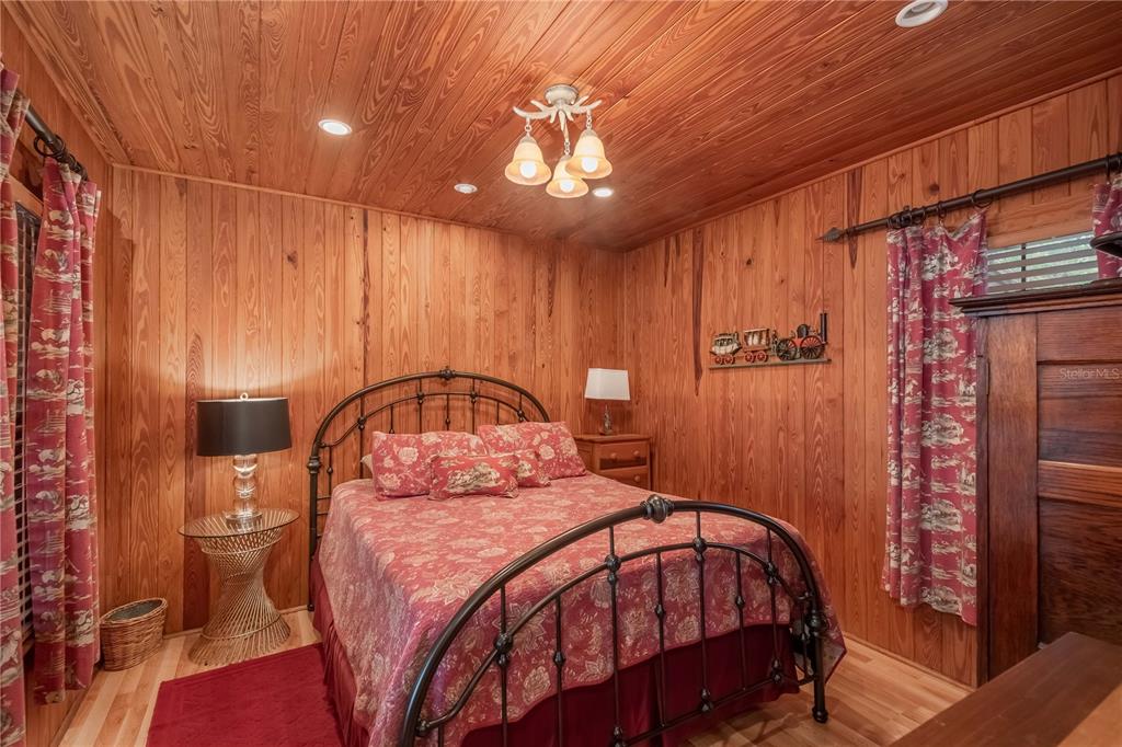 22645 Northeast 105th Avenue Road Fort McCoy, FL 32134 - Photo 13 of 27 a bedroom with a large bed and a chandelier