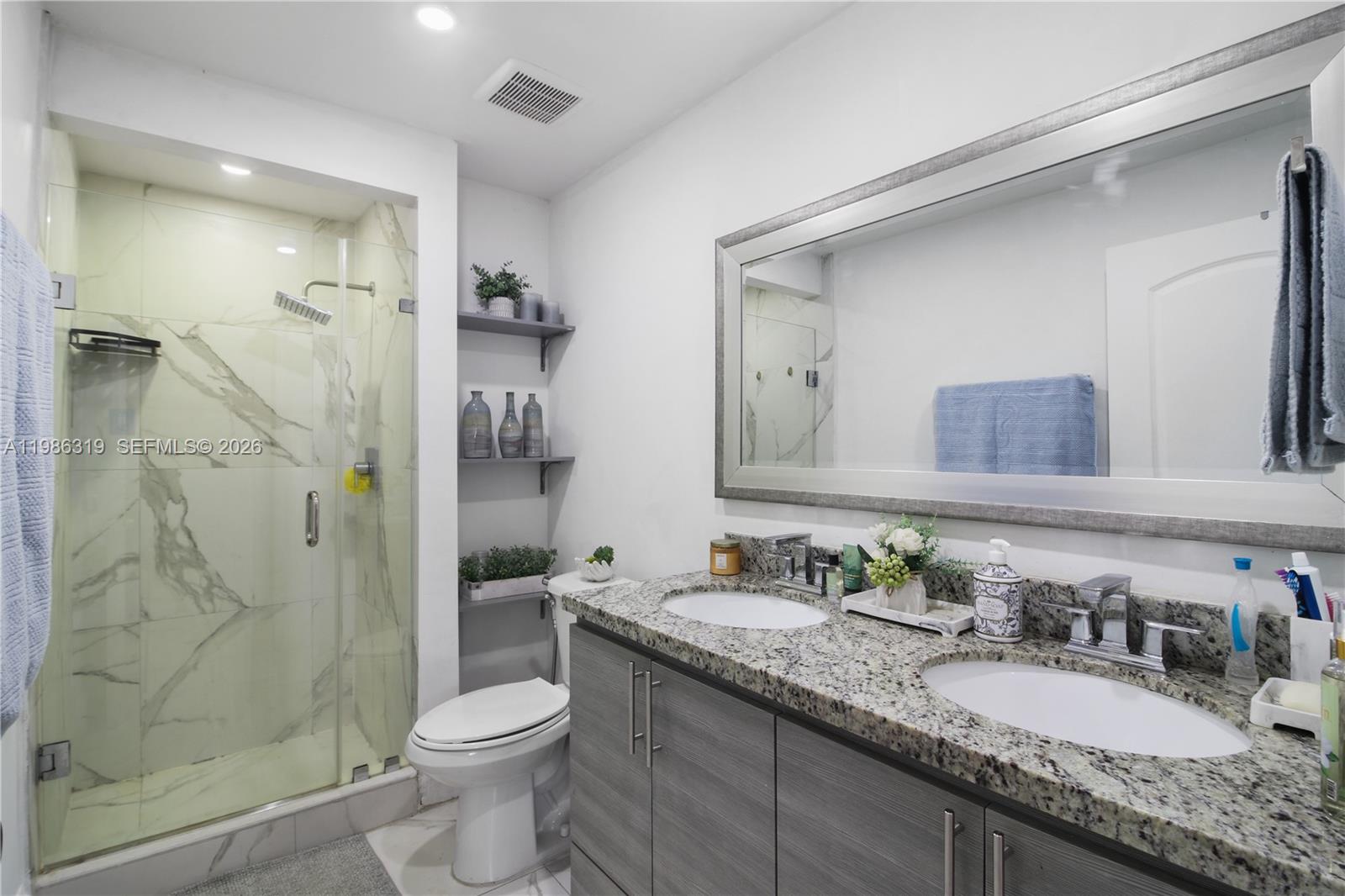 10135 Southwest 139th Place Miami, FL 33186 - Photo 11 of 25 a bathroom with a granite countertop sink toilet and shower