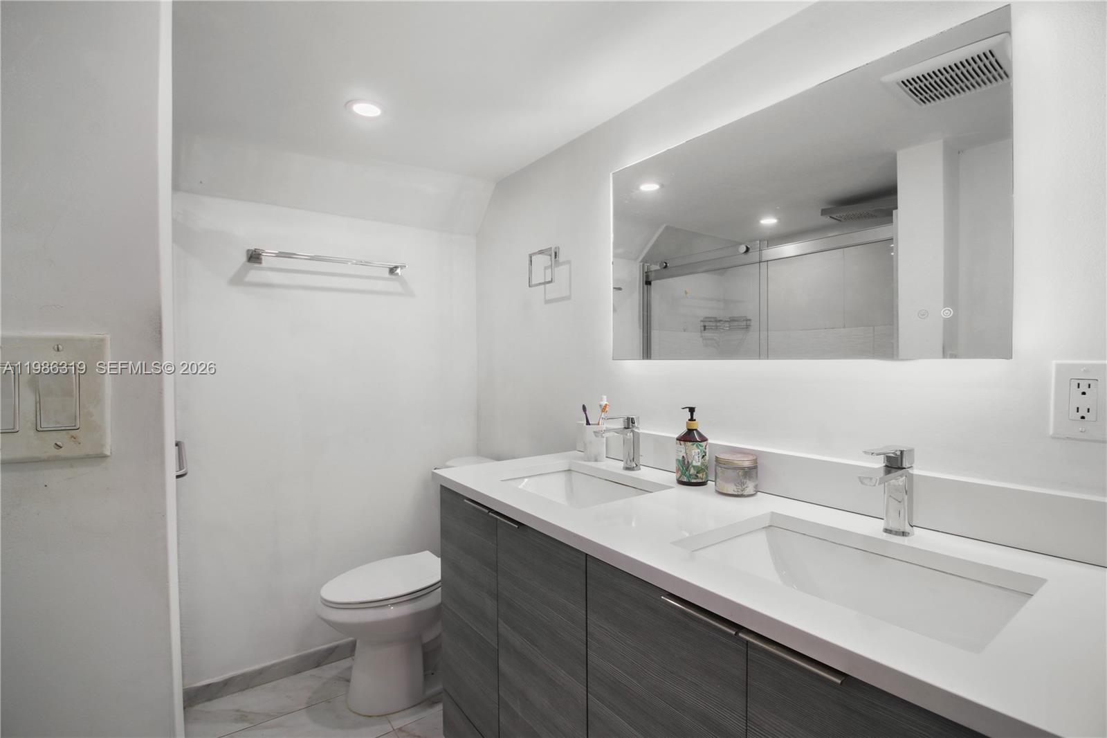 10135 Southwest 139th Place Miami, FL 33186 - Photo 16 of 25 a bathroom with a sink a toilet and a mirror