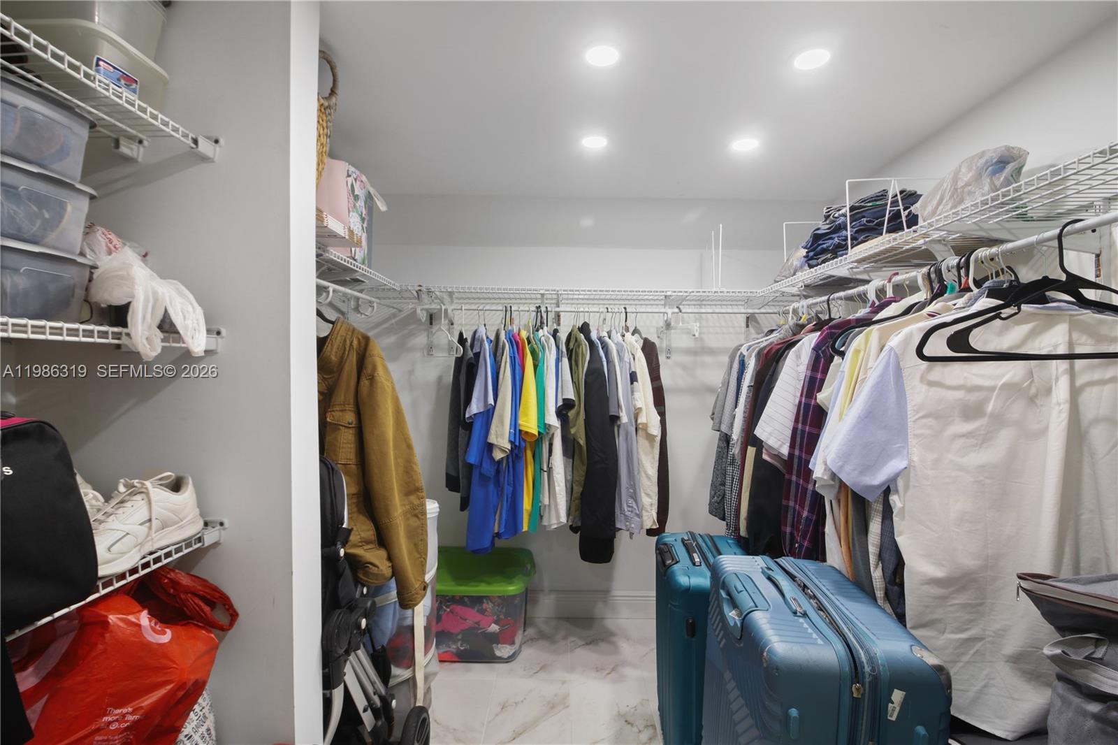 10135 Southwest 139th Place Miami, FL 33186 - Photo 18 of 25 a view of walk in closet with clothes and shoes