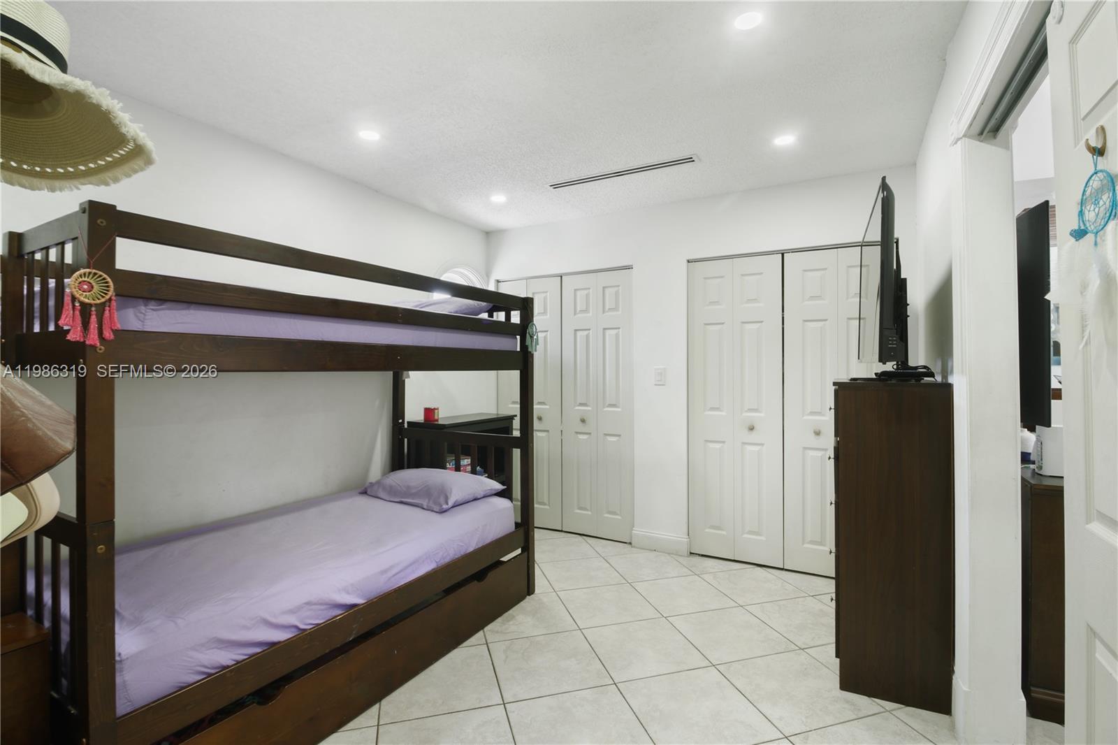 10135 Southwest 139th Place Miami, FL 33186 - Photo 21 of 25 a bedroom with a bed and a refrigerator