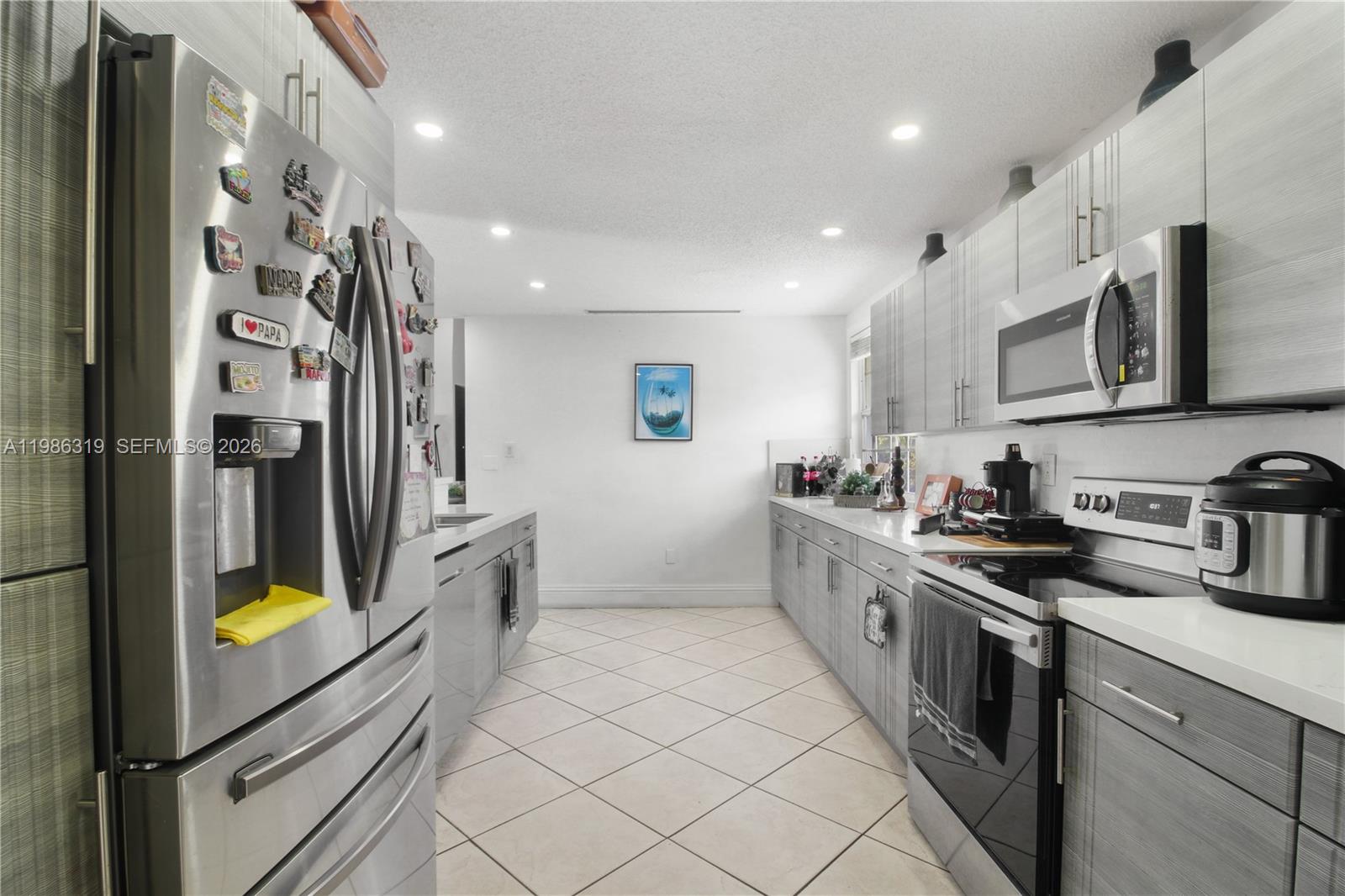 10135 Southwest 139th Place Miami, FL 33186 - Photo 6 of 25 a kitchen with stainless steel appliances a stove a sink and a refrigerator