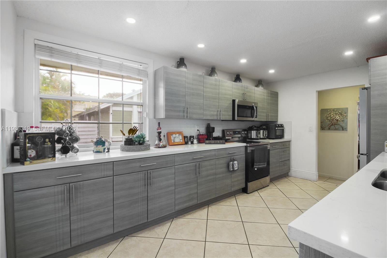 10135 Southwest 139th Place Miami, FL 33186 - Photo 7 of 25 a kitchen with stainless steel appliances granite countertop a stove and a sink