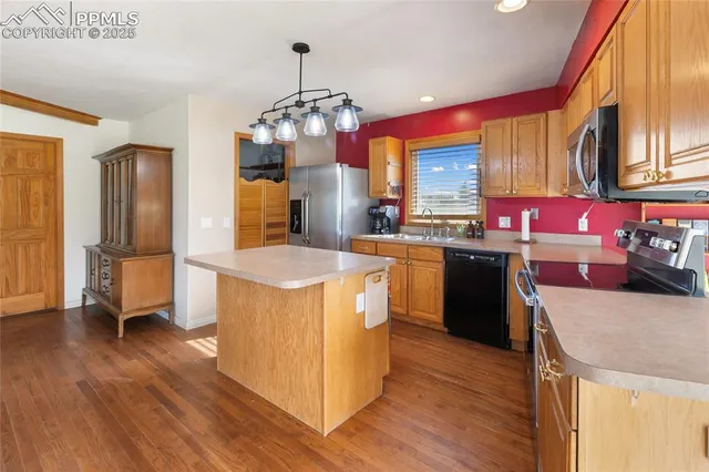 a kitchen with stainless steel appliances granite countertop a sink a stove and a refrigerator