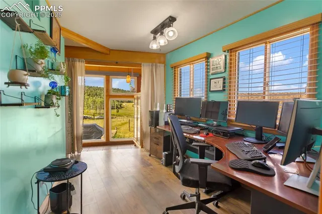 a view of a workspace with furniture and a window