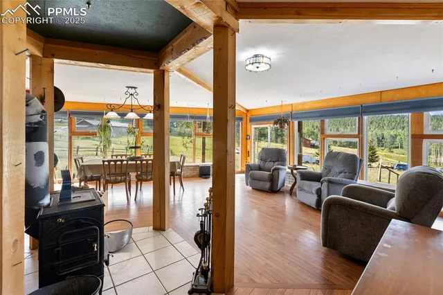 a living room with fireplace furniture and floor to ceiling windows