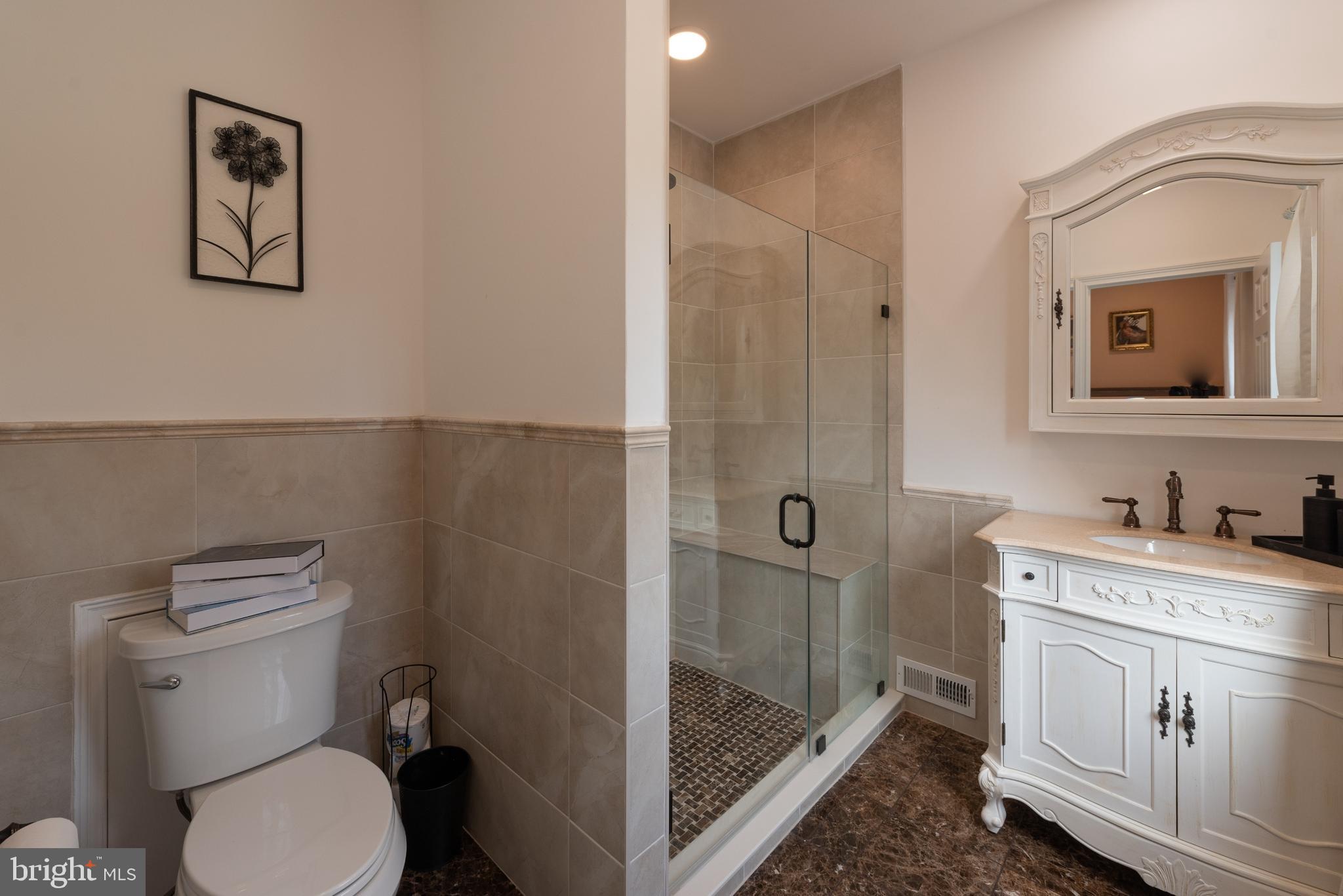 3450 Woodward Road Huntingdon Valley, PA 19006 - Photo 41 of 54 a bathroom with a toilet a sink and glass door