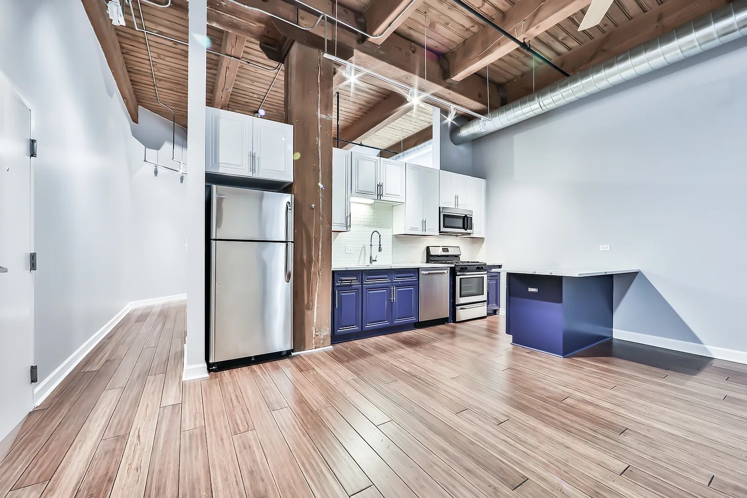1500 West Monroe Street, Unit 206 Chicago, IL 60607 - Photo 2 of 7 a kitchen with wooden floors and white appliances