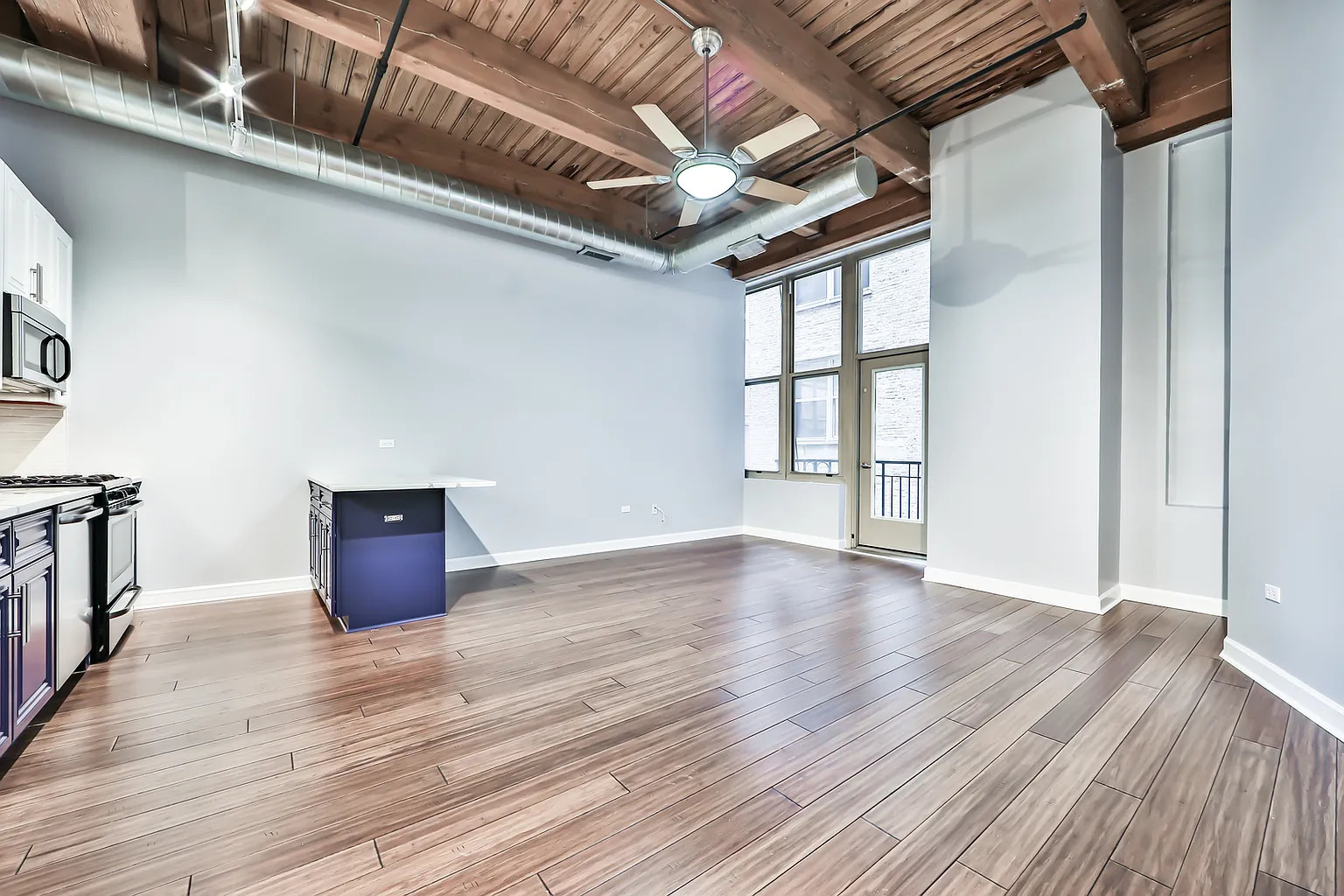 1500 West Monroe Street, Unit 206 Chicago, IL 60607 - Photo 3 of 7 a view of an empty room with wooden floor and a window