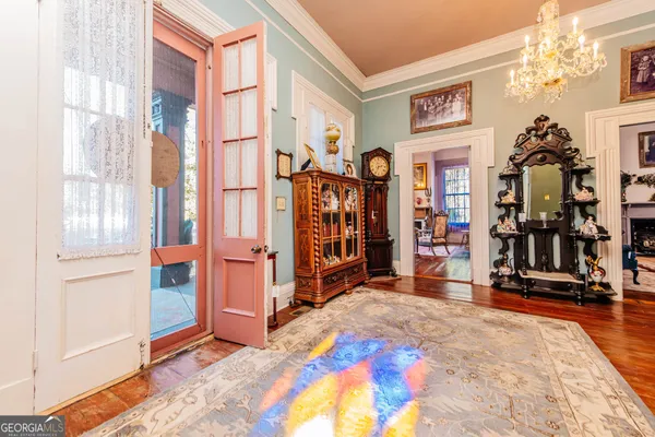 a view of a dining room with furniture a chandelier and wooden floor