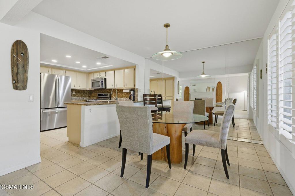19137 Index Street, Unit 9 Porter Ranch, CA 91326 - Photo 11 of 39 a dining room with stainless steel appliances kitchen island granite countertop a table chairs and a refrigerator