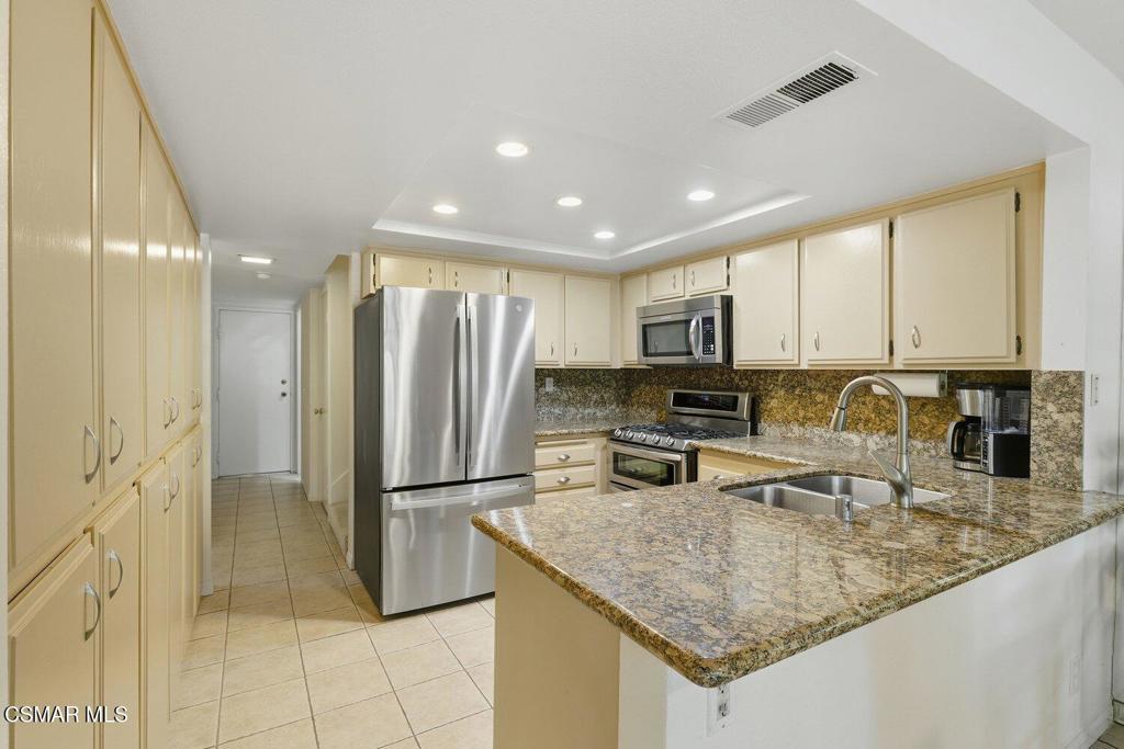 19137 Index Street, Unit 9 Porter Ranch, CA 91326 - Photo 12 of 39 a kitchen with stainless steel appliances granite countertop a refrigerator a stove and a sink