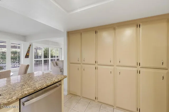 a kitchen with stainless steel appliances granite countertop white cabinets and window