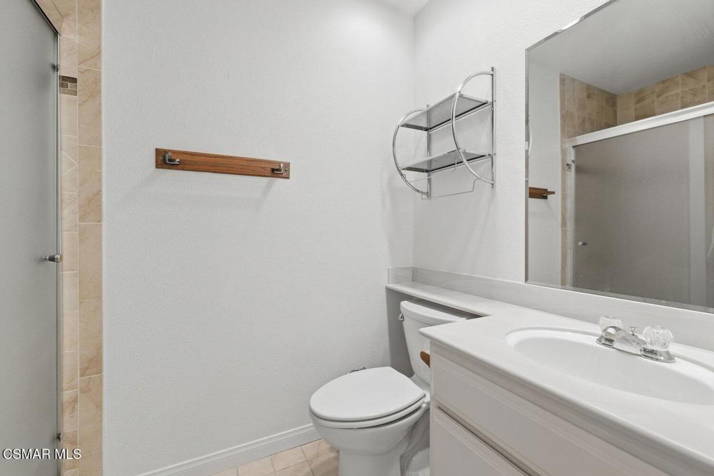 19137 Index Street, Unit 9 Porter Ranch, CA 91326 - Photo 24 of 39 a bathroom with a granite countertop sink toilet and a mirror