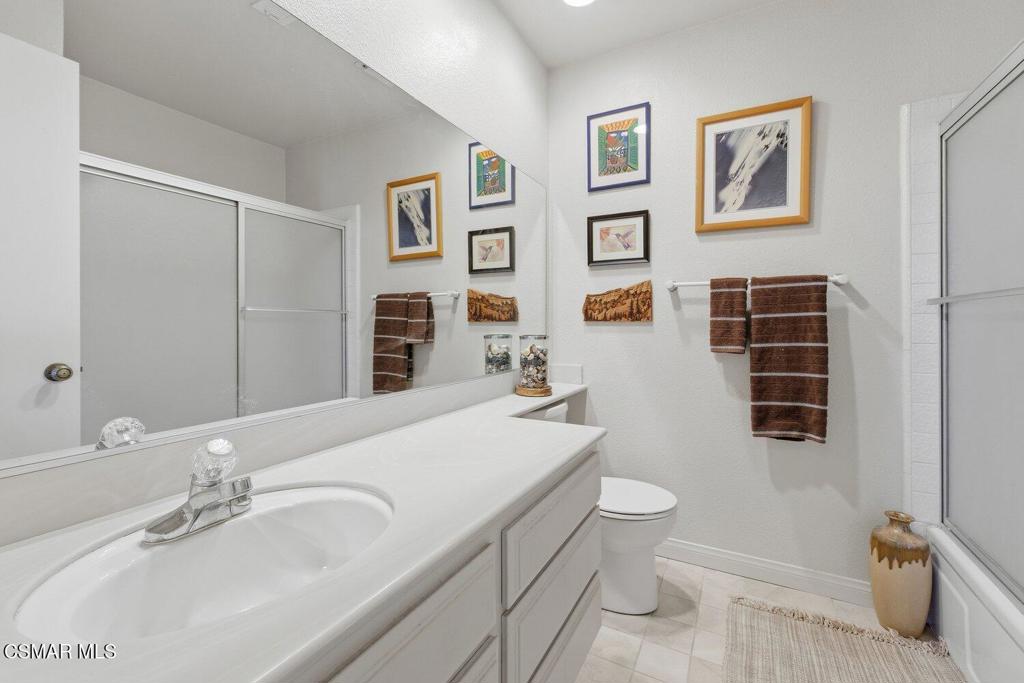19137 Index Street, Unit 9 Porter Ranch, CA 91326 - Photo 26 of 39 a bathroom with a granite countertop sink mirror vanity and toilet