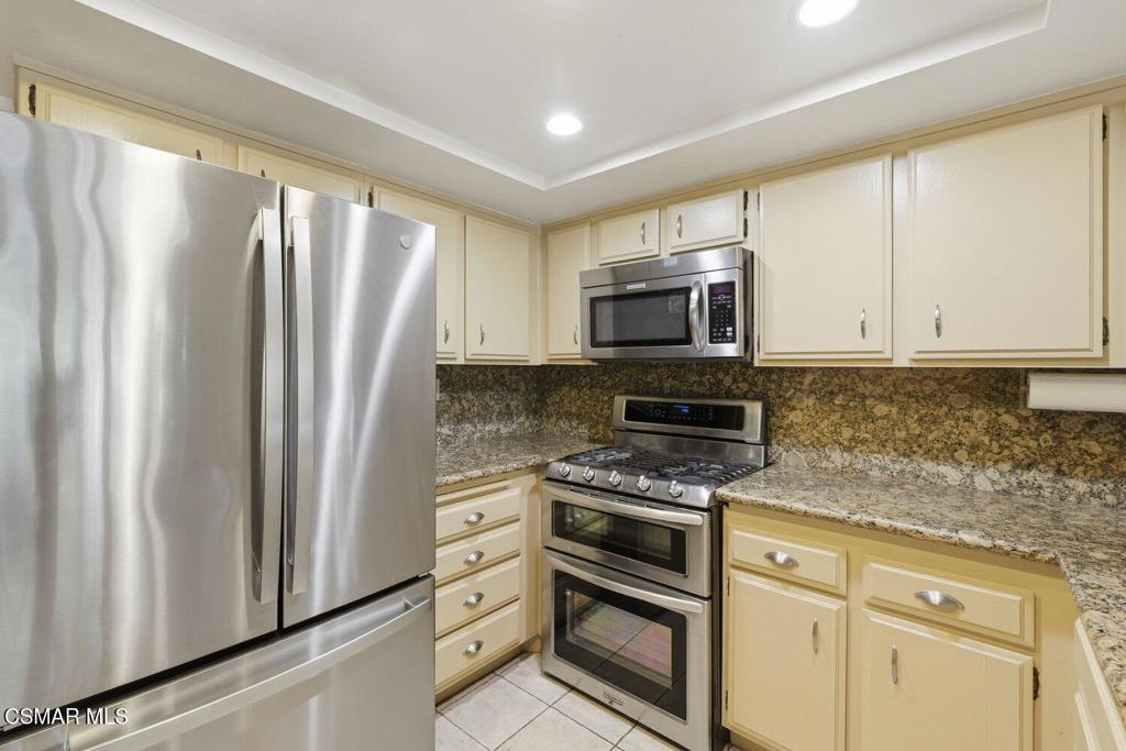 19137 Index Street, Unit 9 Porter Ranch, CA 91326 - Photo 9 of 39 a kitchen with granite countertop a refrigerator stove and microwave