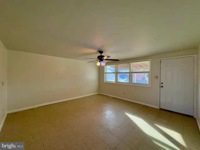 an empty room with a window and a ceiling fan