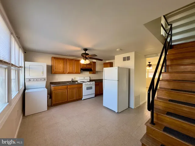 a kitchen with refrigerator and wooden cabinets