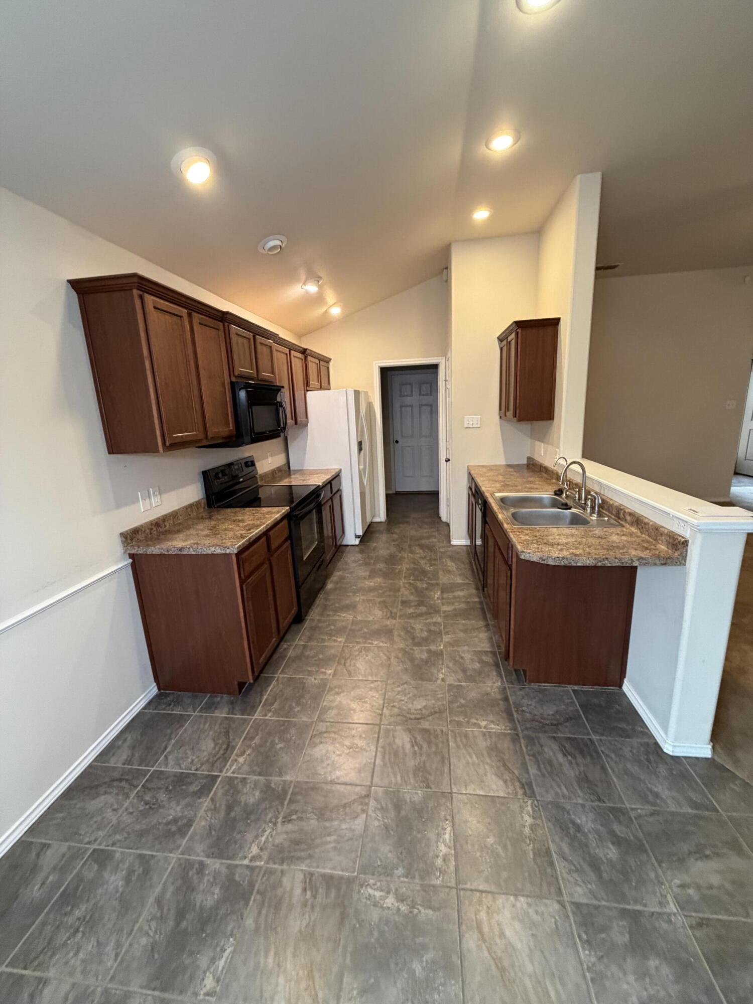 6544 84th Street Lubbock, TX 79424 - Photo 11 of 29 a living room with kitchen island furniture and a flat screen tv