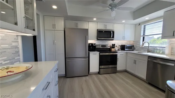 a kitchen with a sink a stove a refrigerator and black cabinets