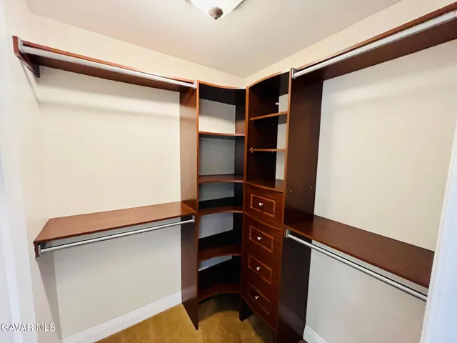 a view of walk in closet with clothes