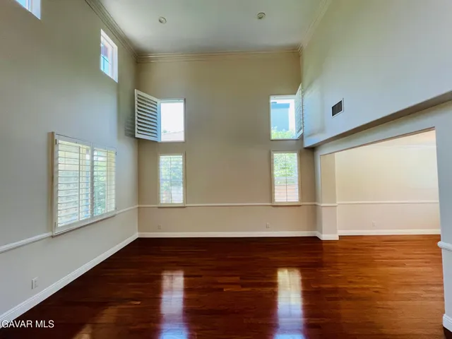 a room with wooden floor and windows