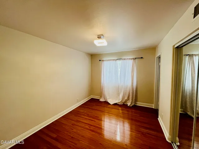 an empty room with wooden floor and a window