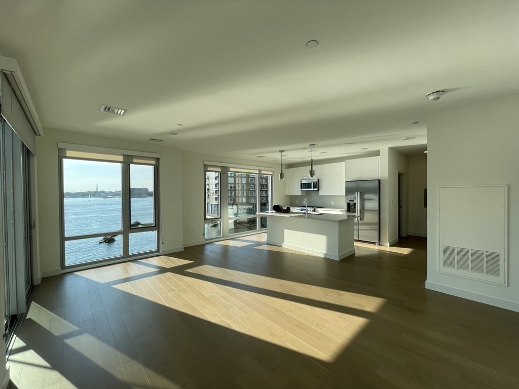 45 Lewis Street, Unit 310 Boston, MA 02128 - Photo 2 of 11 a large kitchen with kitchen island a sink stainless steel appliances and cabinets