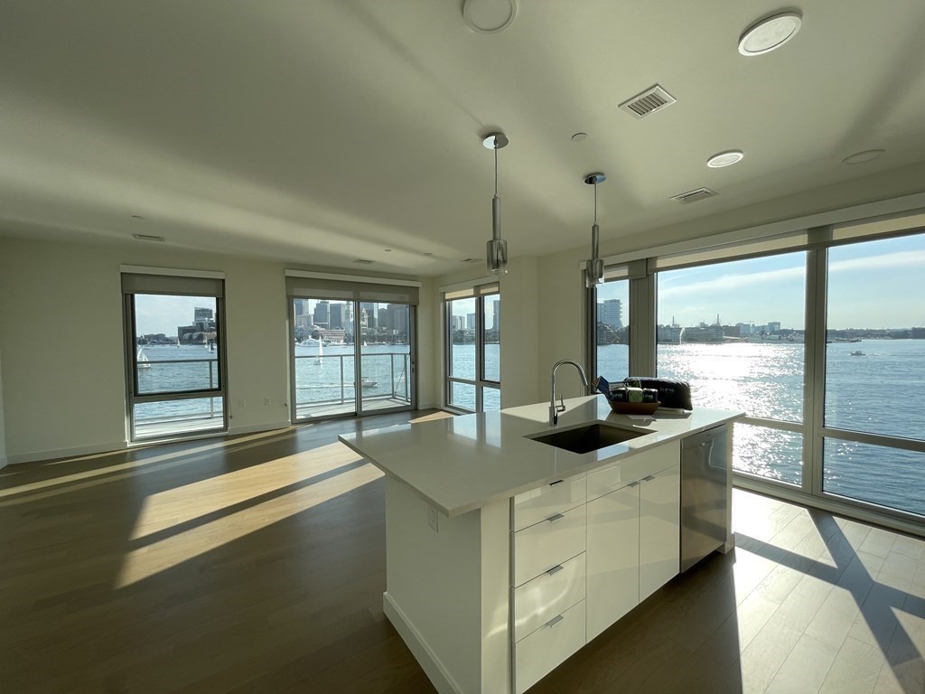 45 Lewis Street, Unit 310 Boston, MA 02128 - Photo 3 of 11 a kitchen with stainless steel appliances granite countertop a sink and a large window