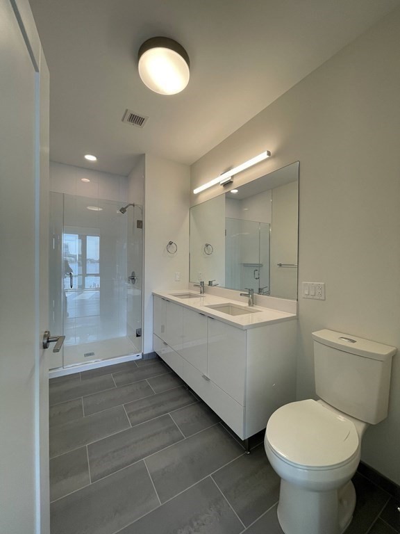45 Lewis Street, Unit 310 Boston, MA 02128 - Photo 6 of 11 a bathroom with a toilet sink and mirror
