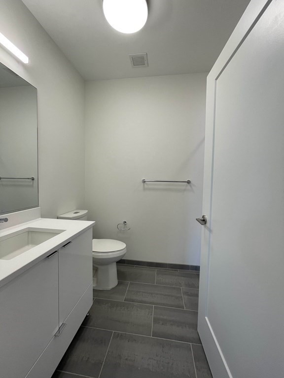 45 Lewis Street, Unit 310 Boston, MA 02128 - Photo 9 of 11 a bathroom with a sink a toilet and mirror