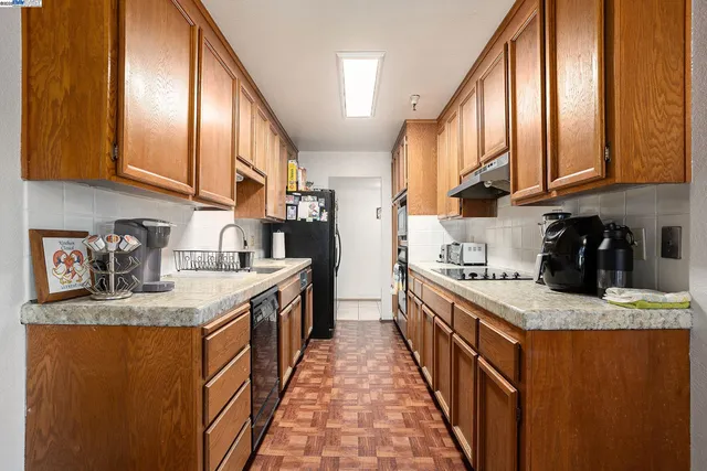 a kitchen with stainless steel appliances granite countertop a refrigerator and a stove