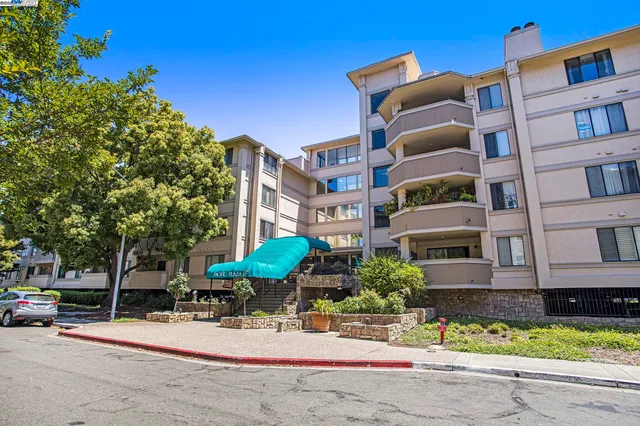 a view of tall building with large trees and plants