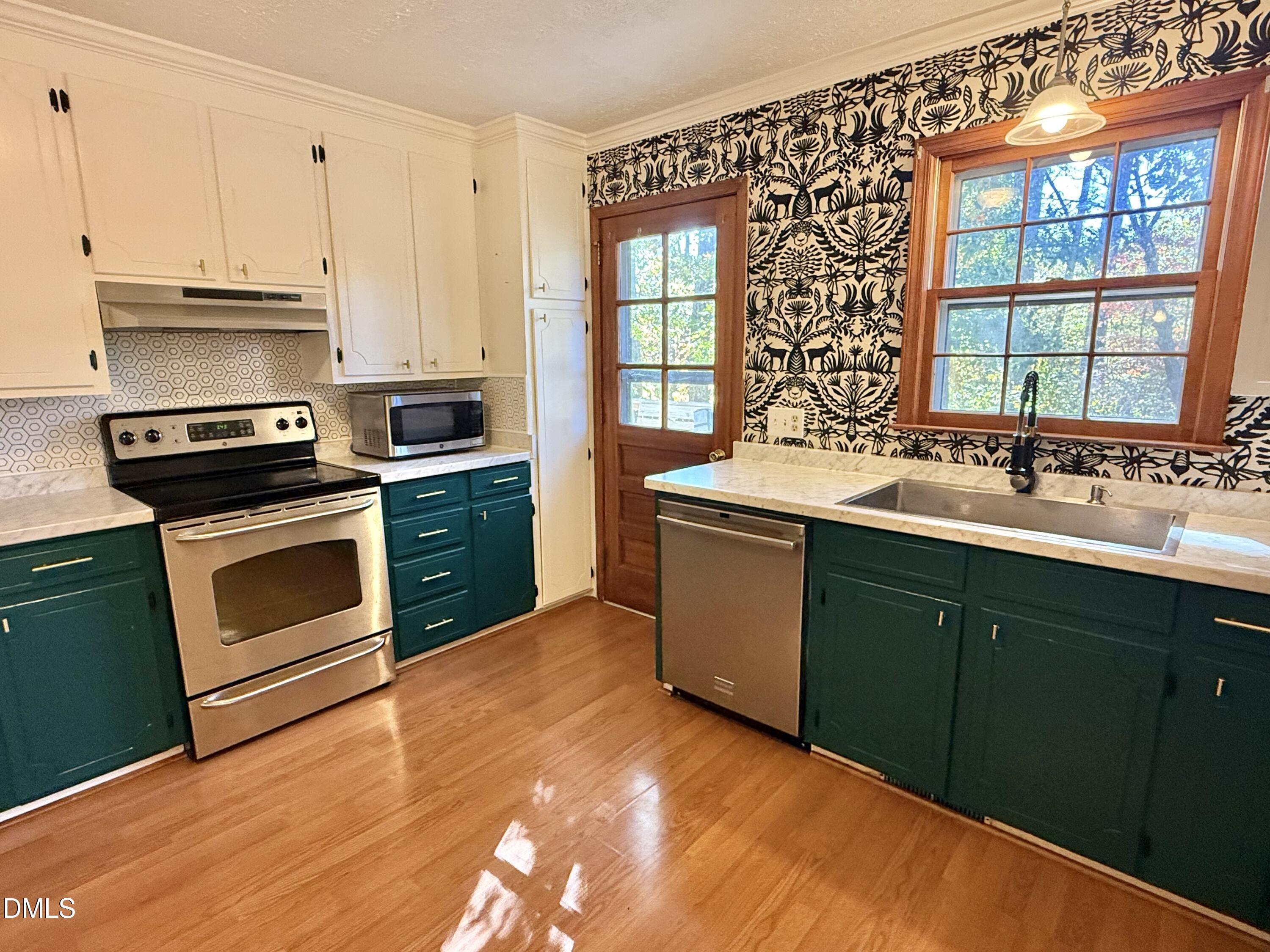 2320 Poindexter Road Hurdle Mills, NC 27541 - Photo 11 of 57 a kitchen with stainless steel appliances granite countertop a stove a sink and a microwave