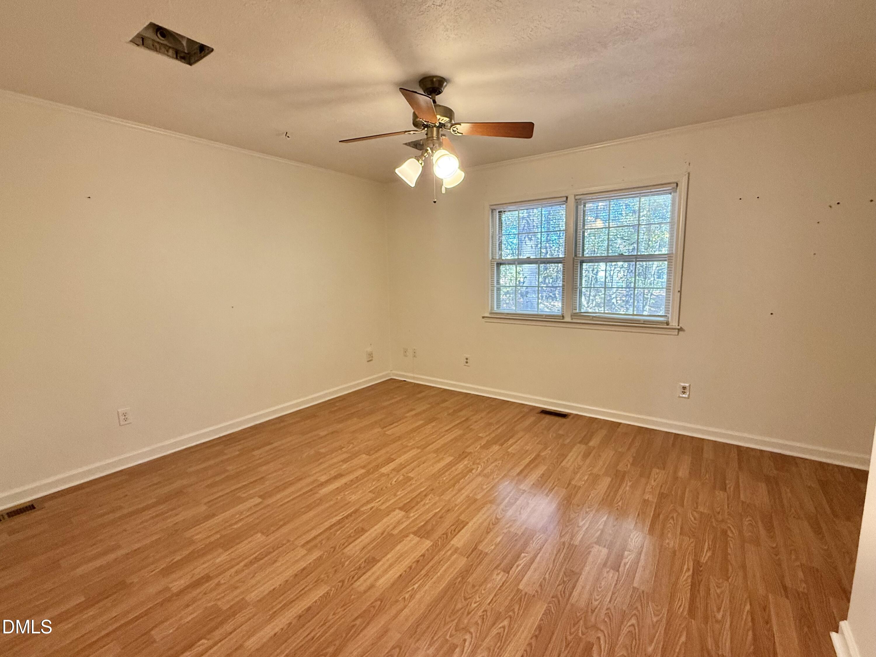 2320 Poindexter Road Hurdle Mills, NC 27541 - Photo 13 of 57 an empty room with wooden floor fan and windows