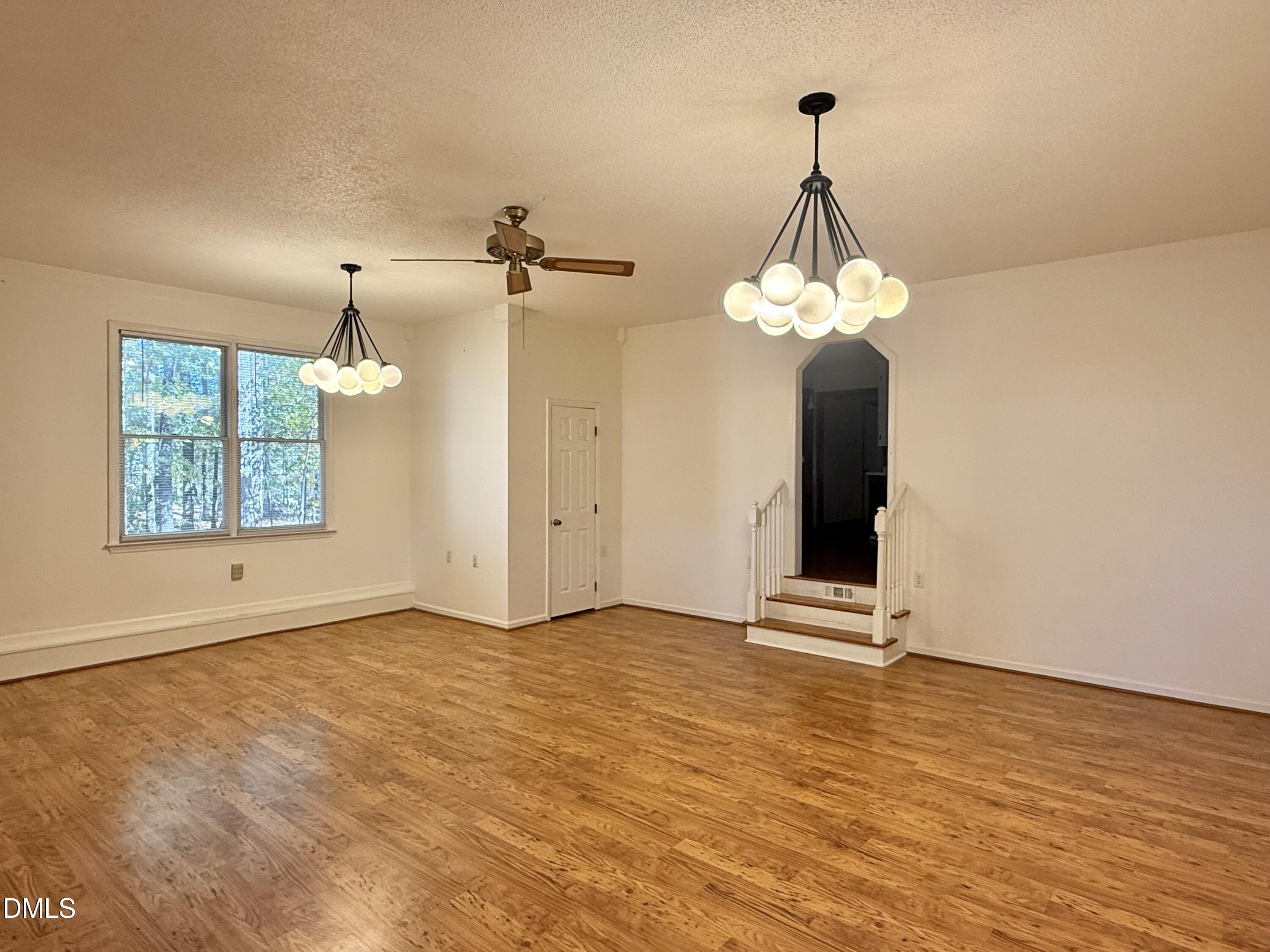 2320 Poindexter Road Hurdle Mills, NC 27541 - Photo 3 of 57 an empty room with wooden floor chandelier and windows