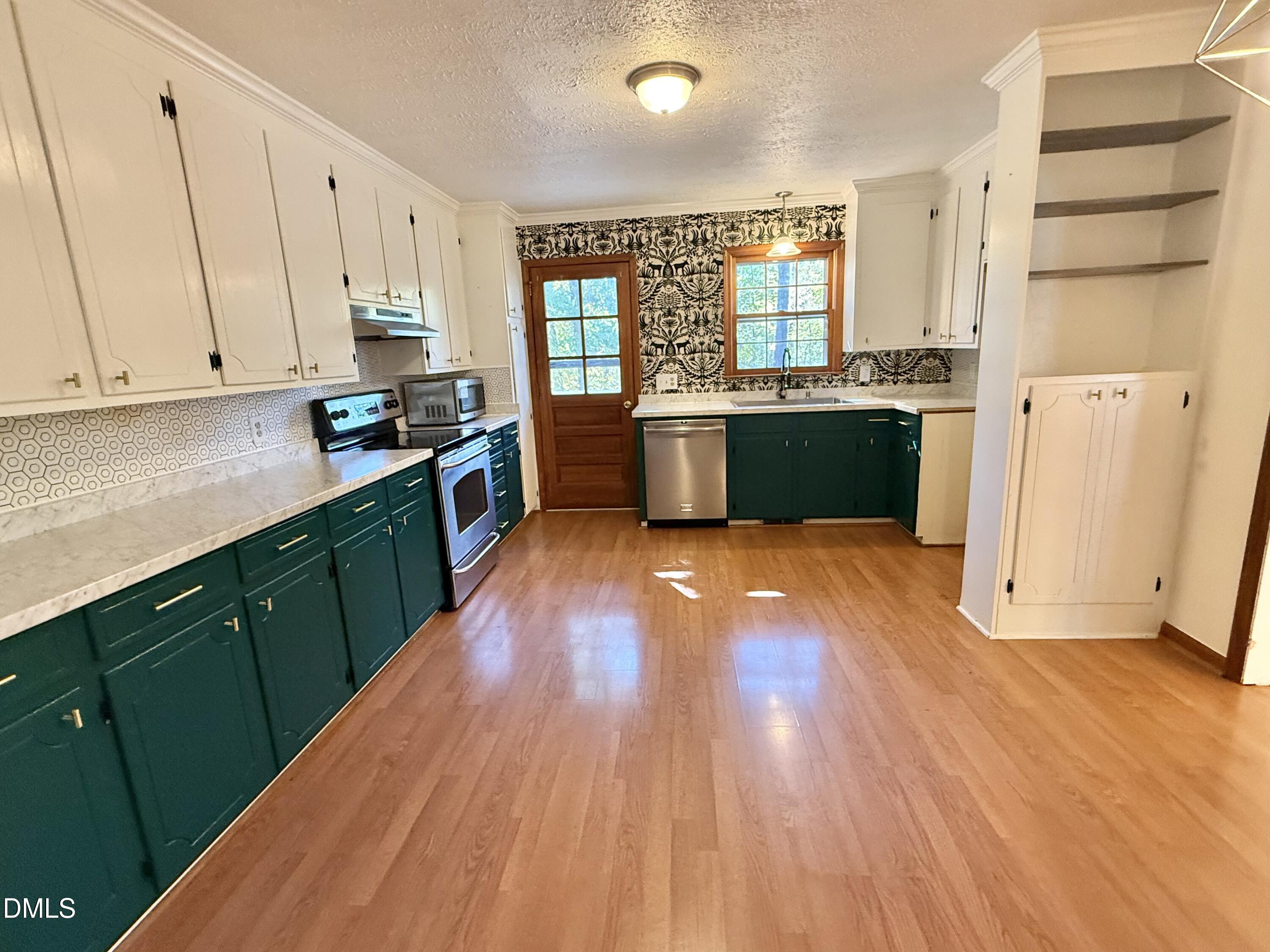 2320 Poindexter Road Hurdle Mills, NC 27541 - Photo 6 of 57 a large kitchen with wooden floors and white stainless steel appliances