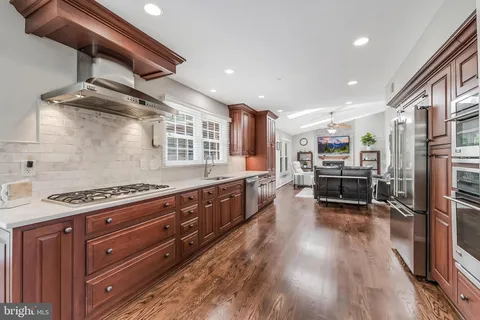 a kitchen with a refrigerator and a stove top oven