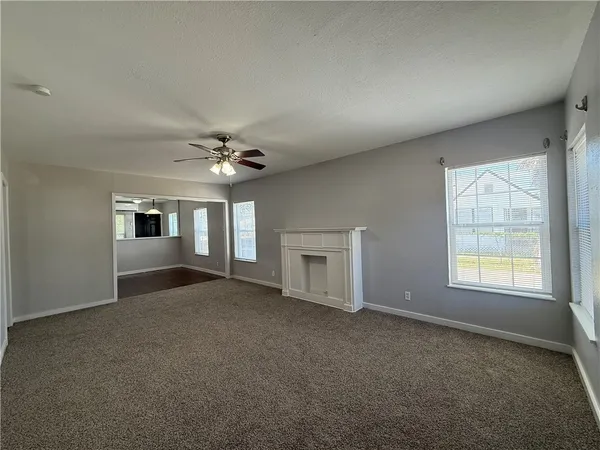 an empty room with chandelier and windows
