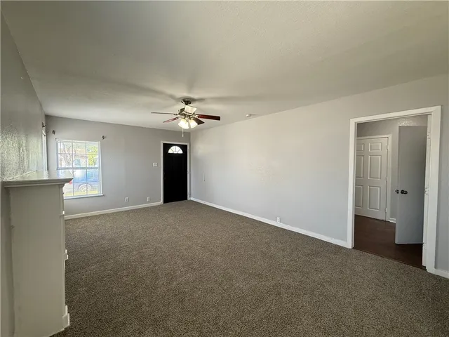 a view of a big room with windows and chandelier fan