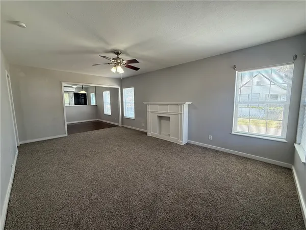 an empty room with windows and fireplace