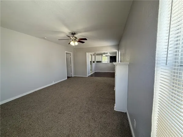 a view of a livingroom with a ceiling fan and window