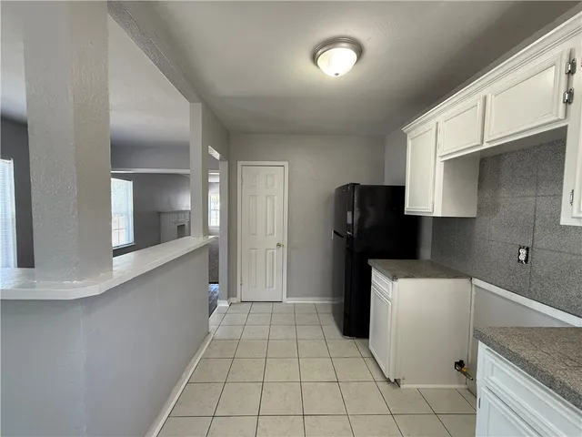 a kitchen with a refrigerator and cabinets