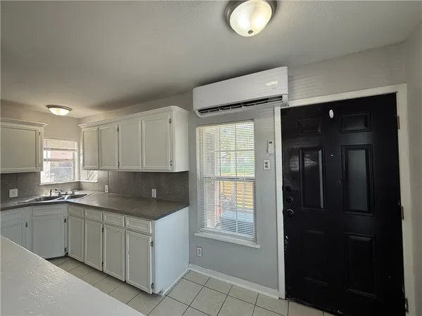 a kitchen with a sink window and cabinets