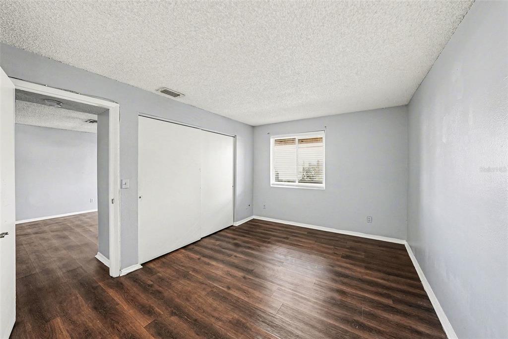 550 Golden Raintree Place, Unit 550 Brandon, FL 33510 - Photo 15 of 33 an empty room with wooden floor cabinet and windows