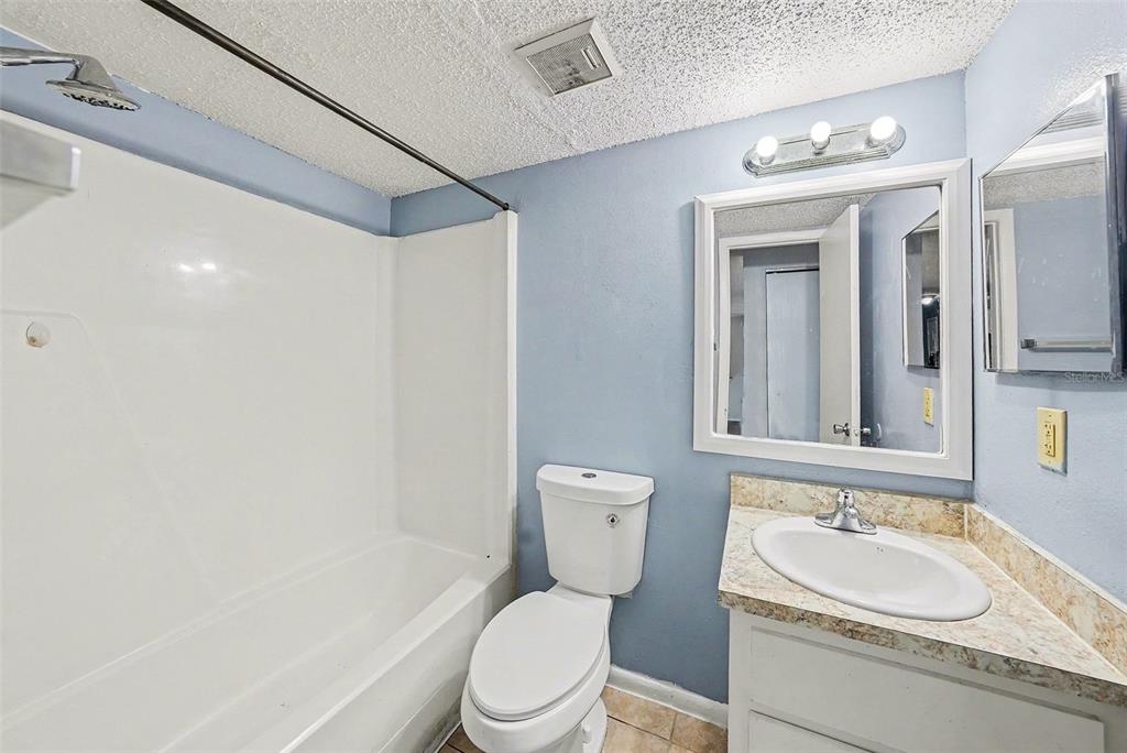 550 Golden Raintree Place, Unit 550 Brandon, FL 33510 - Photo 22 of 33 a bathroom with a granite countertop sink a toilet and a mirror