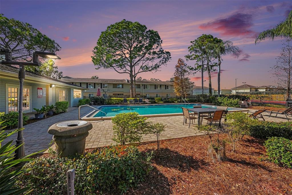 550 Golden Raintree Place, Unit 550 Brandon, FL 33510 - Photo 28 of 33 a view of a swimming pool with a patio and a garden